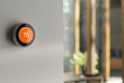 Smart thermostat on a wall showing 70 degrees fahrenheit